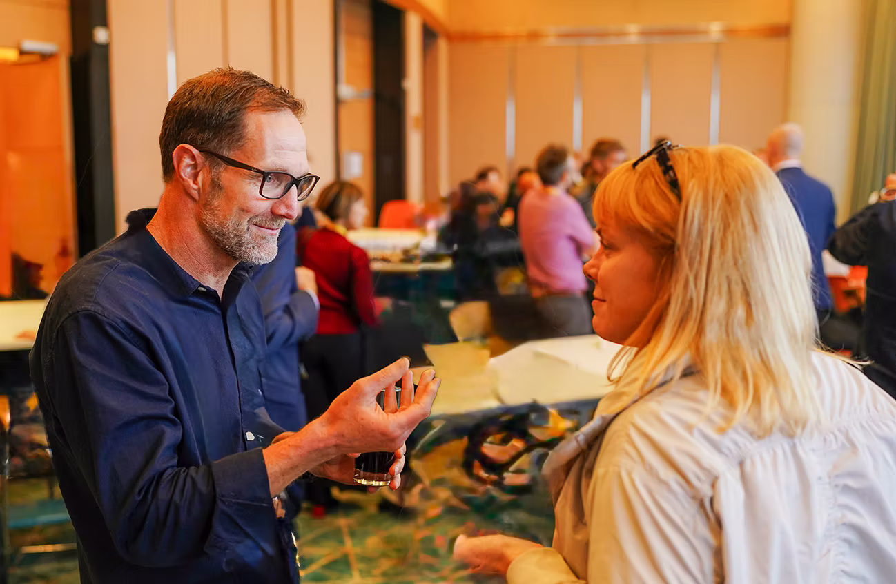 Image of The Wellbeing Distillery co-founder Justin Robertson speaking to someone at an event.